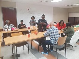 Detroit Poilce Department officer Deanna Merriweather shows a class of residents how to crochet.