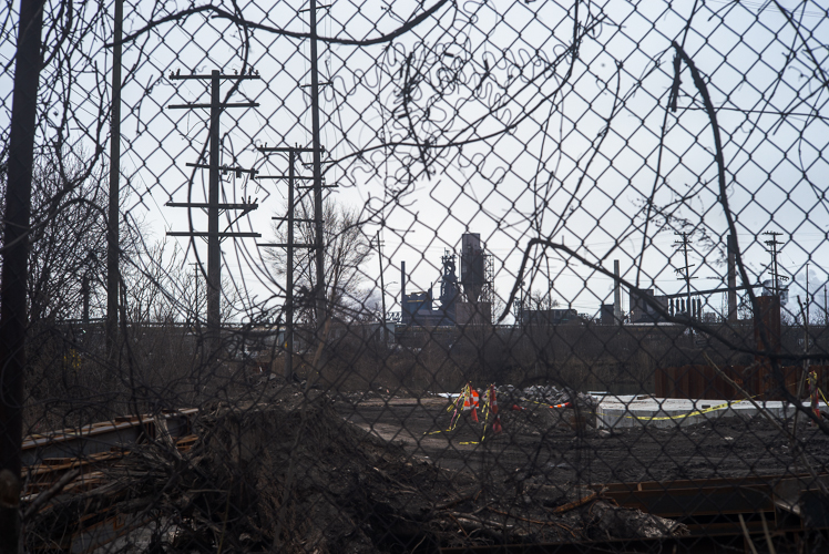 Delray's industrial landscape as seen through a fence.