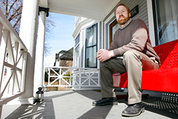 Bill Swanson sits on his front porch
