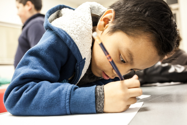 A young writer at work during an 826Michigan workshop at the Campbell Branch Library