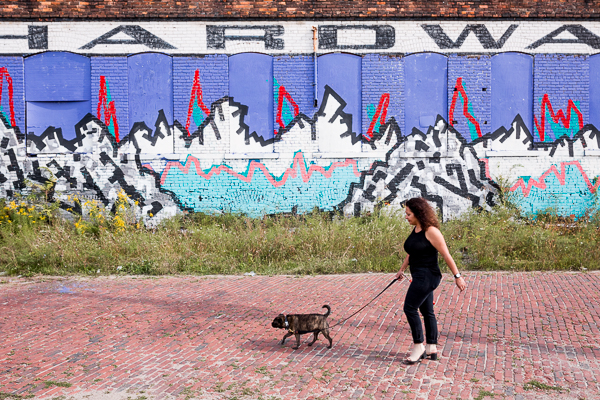 David with her dog in front of a mural
