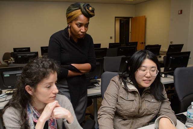 Sisters Code instructor Ronisha Harvey goes over a coding challenge with two students