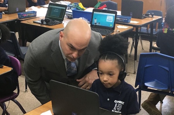 Superintendent Nikolai Vitti works with a student on a personal computer at Cooke STEM Academy