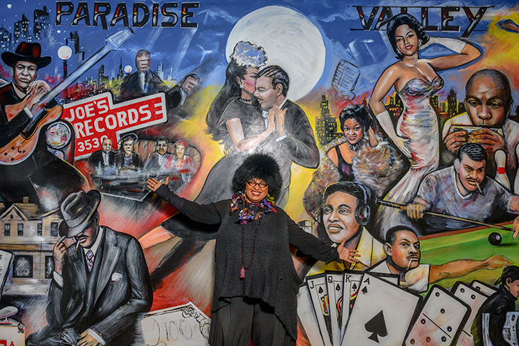 Marsha Music pointing out her father's record store and her father in Curtis Lewis' mural