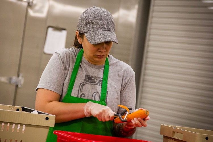 Jessie Burnell, food hub operations coordinator, peels a sturdy carrot at ValleyHUB.