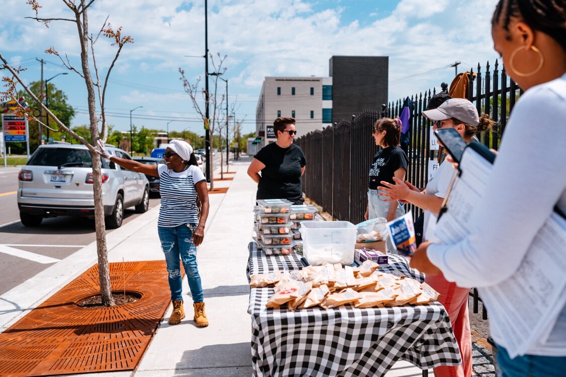 Belinda Gilmore waves to a passer-by during a May lunch giveaway on Kercheval.