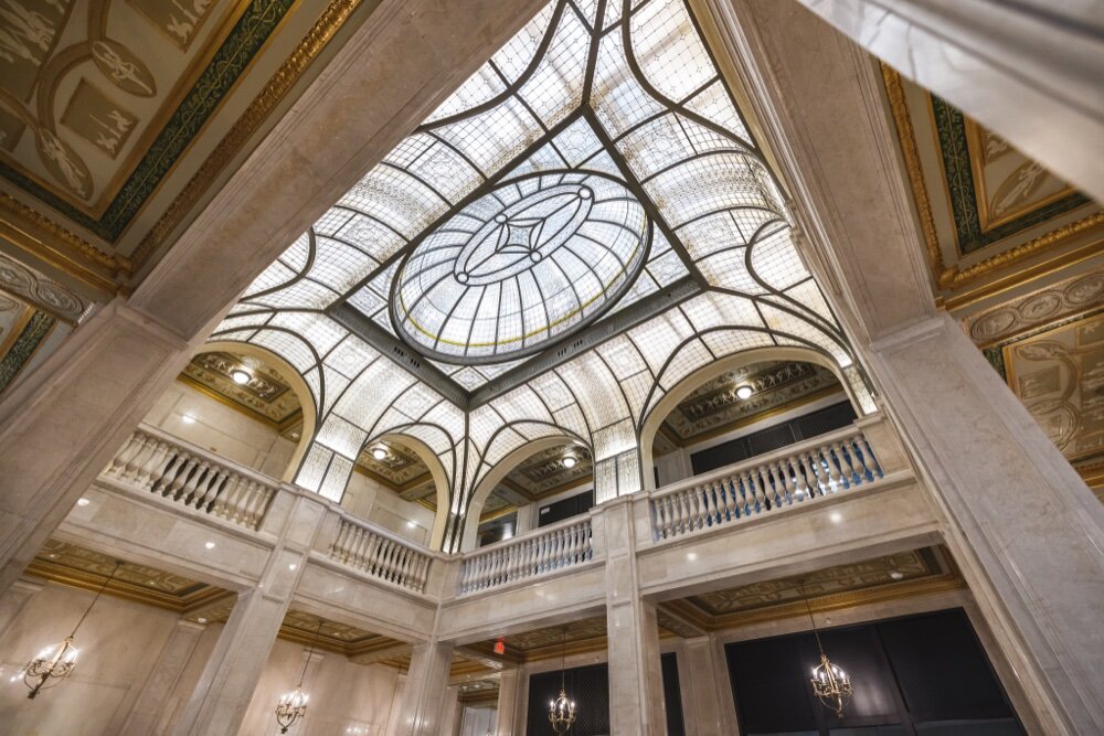 A restored 1920s art-glass skylight features more than 7,000 individual glass jewels and 6,000 glass panels in the three-story atrium of the Book Tower.