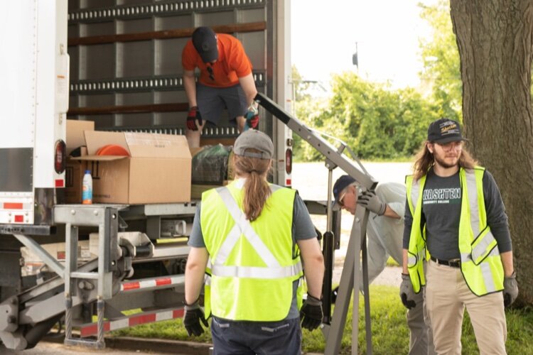 Workers unload streetlight equipment at Avalon Village.