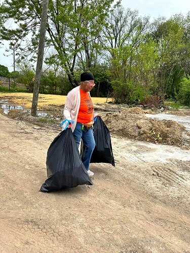 A CRCAA volunteer participates in a community cleanup of the future senior housing site.