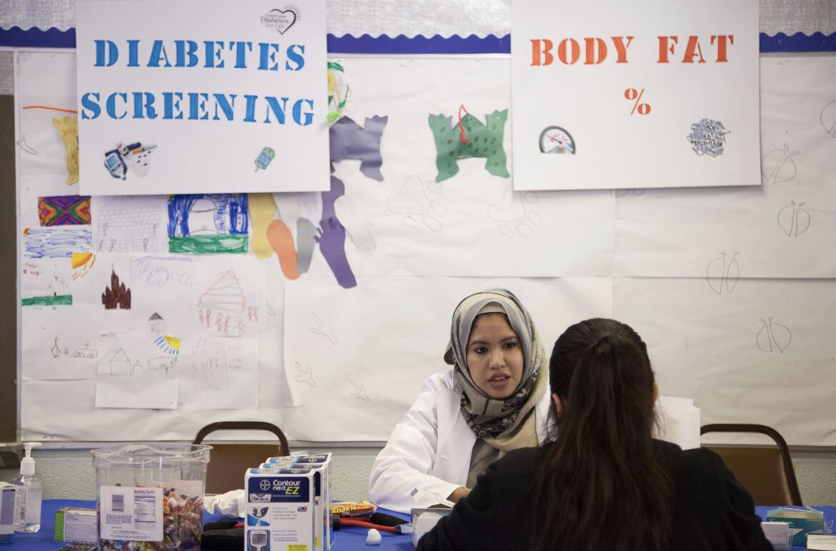 Begum screens a patient for diabetes. Courtesy photo.