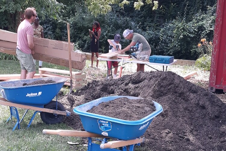 Workers build raised bed gardens at the East Village Community Picnic Area.