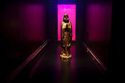 Bathed in fuchsia light, a golden Madonna beckons to visitors of the Future Distortion installation.