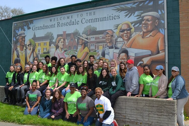 GRDC supporters gather in front of a community mural in the days before COVID-19.