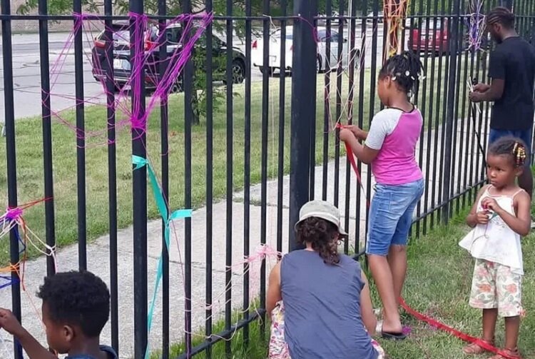 Residents of Hope Village decorate a fence.