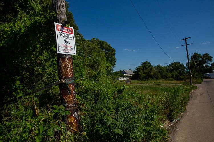 A sign warns illegal dumpers they're being watched at this East Side location.