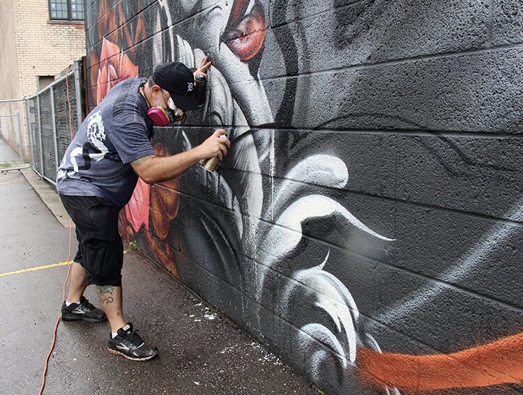 On day 5, the muralist is down to details on "The Justice Wall."