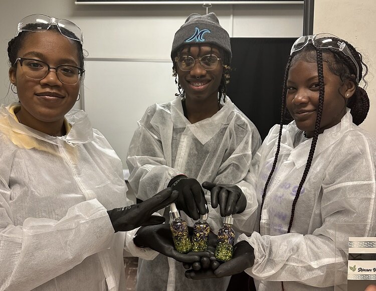 Rebecca Smith, Ka’Shon Ringold, and Leah Solomon with a face oil they created.