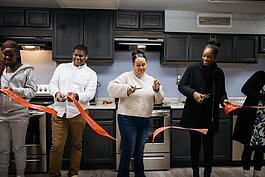 Members of TAC cut a ribbon for The Vault's newly renovated kitchen.