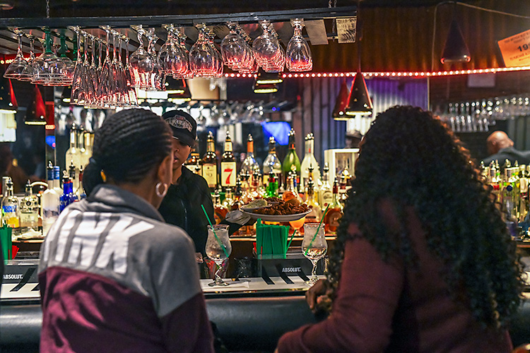 Patrons order drinks at Baker's iconic keyboard-styled bar.