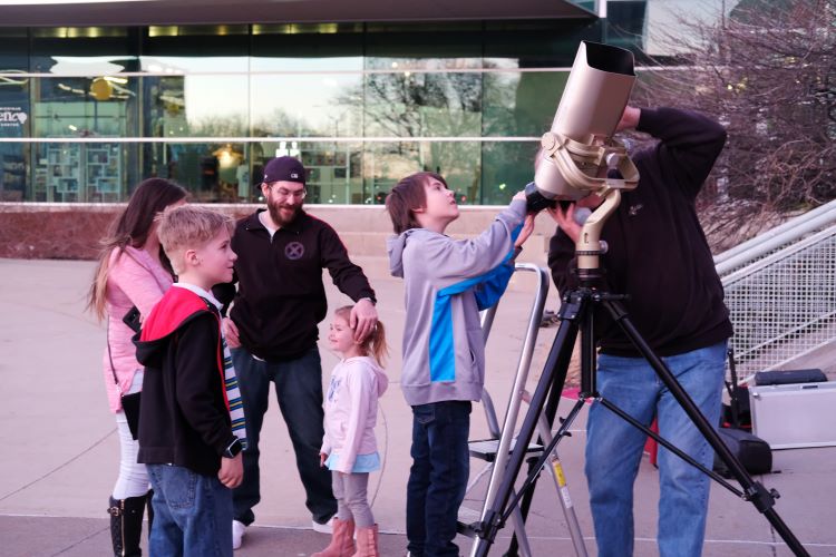 Students look through a telescope.