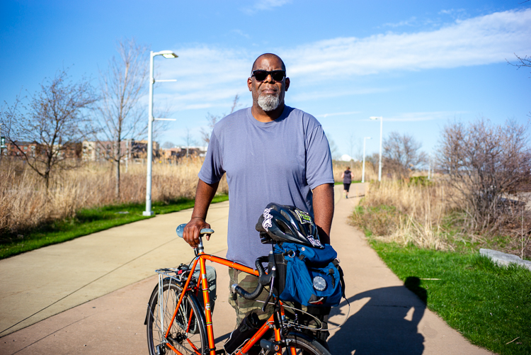 Henry Ford II walks his bike on Detroit's RiverWalk.