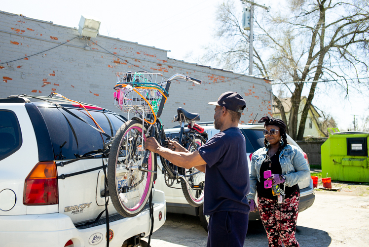 Scott Ford helps Melissa Williams mount a bike on a car.