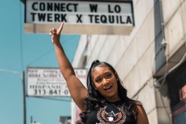 Lauren McGrier points to an El Club billboard advertising her Twerk x Tequila event.