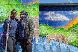 Springboard to Excellence Program Coordinator, Jainabou Barry-Danfa (left), and ABISA's Community Outreach and Engagement Coordinator, Fanta Jatta (right), stand for a portrait together at the Brightmoor Artisans Collective. 