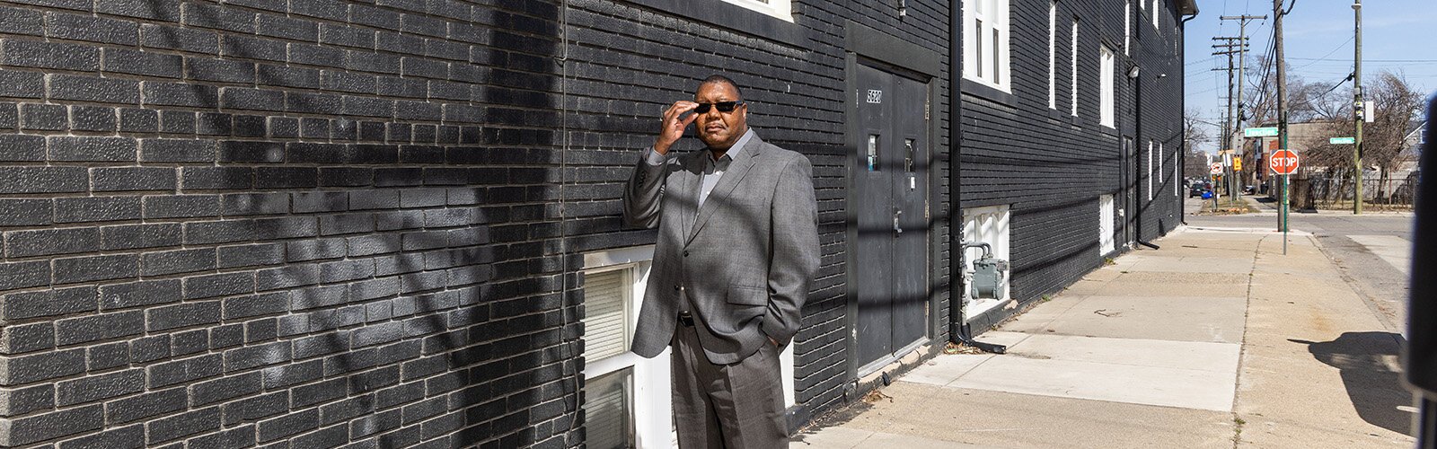 Bobby D. Lewis stands by his apartment complex in SW Detroit.