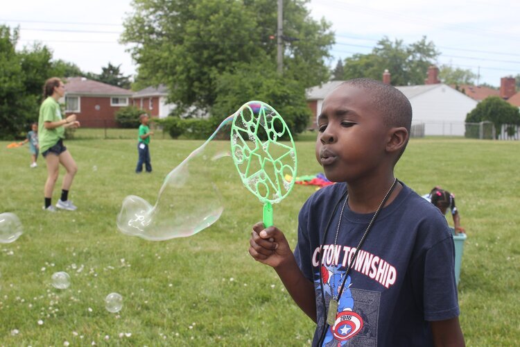 A young camper blows bubbles at LifeBUILDERS summer camp.