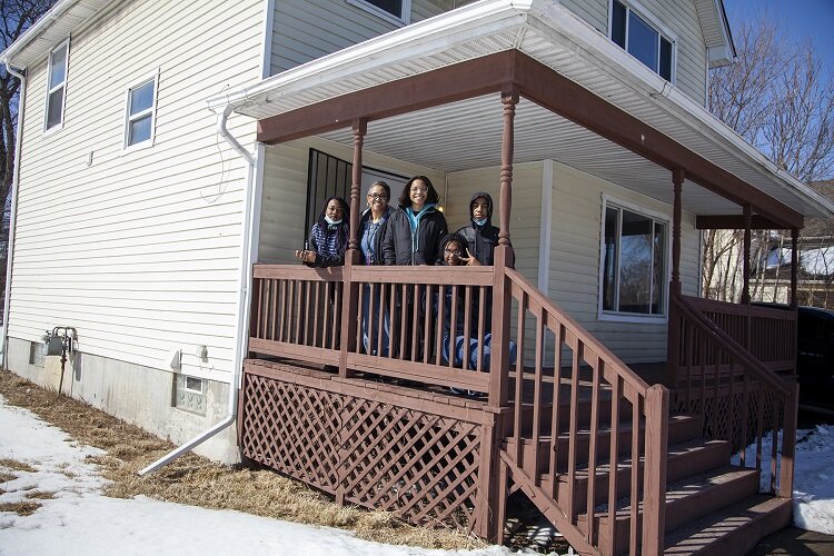 Leslie Jackson and her family pose in front of their new home.