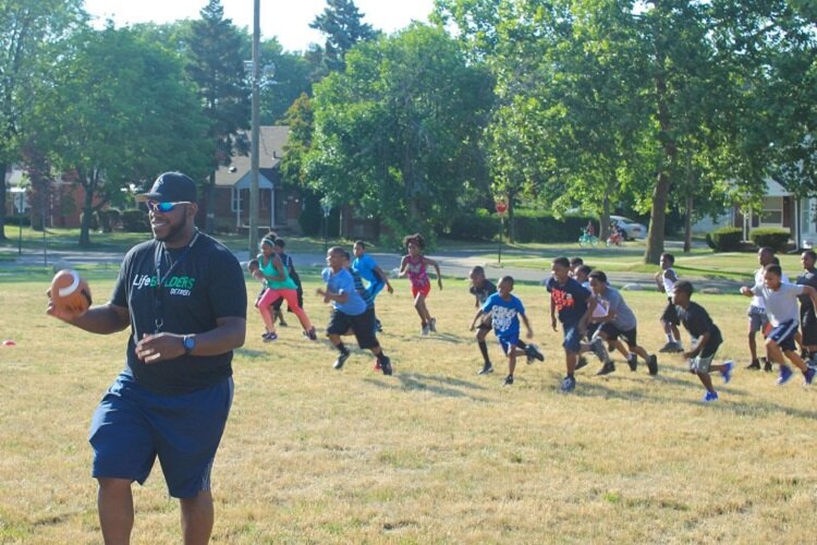 LifeBUILDERS youth play football with DeAngelo Mabone prior to the pandemic.