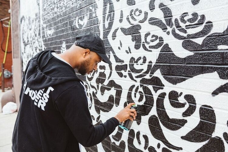 The Detroit-based artist Marlo works on a mural.