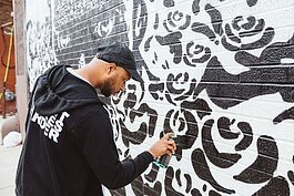 The Detroit-based artist Marlo works on a mural.