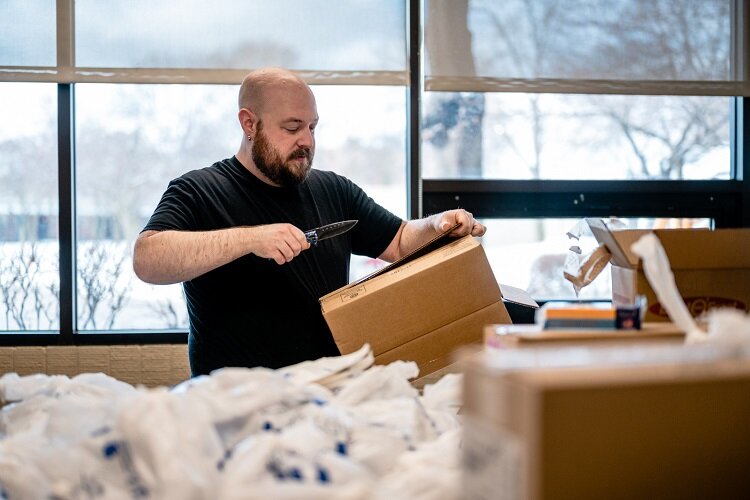 Mick Dettloff helps assemble boxes for the Raising Hope Senior Program.