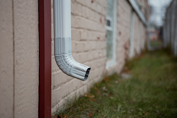 Downspout adjusted to drain into the grass adjacent to a house owned by First Spanish Baptist Church