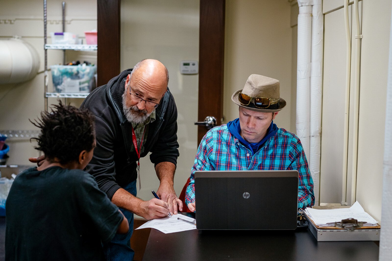 Mark Schroeder and Jeff Hunt assist a patient at St. Peter and Paul Jesuit Church where the street team has a weekly clinic.