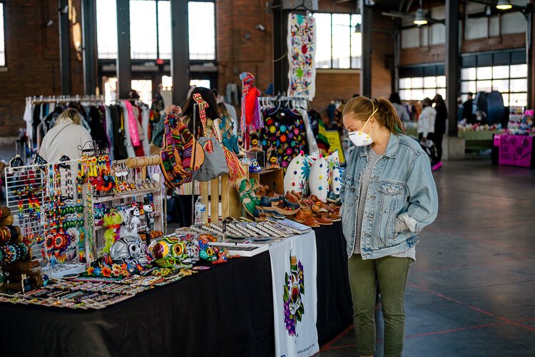 A shopper peruses local items at Eastern Market's Sunday Market earlier this year. Holiday Markets are back, with Sunday markets focusing on local vendors selling everything from beauty products to T-shirts.