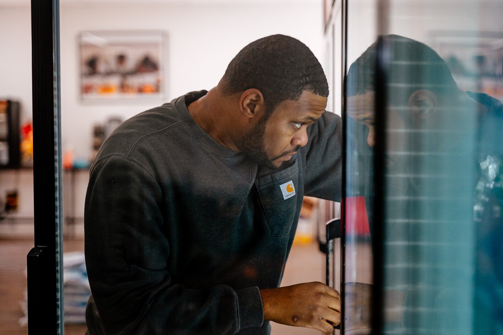 Raphael Wright stocking shelves in the coolers of Neighborhood Grocery