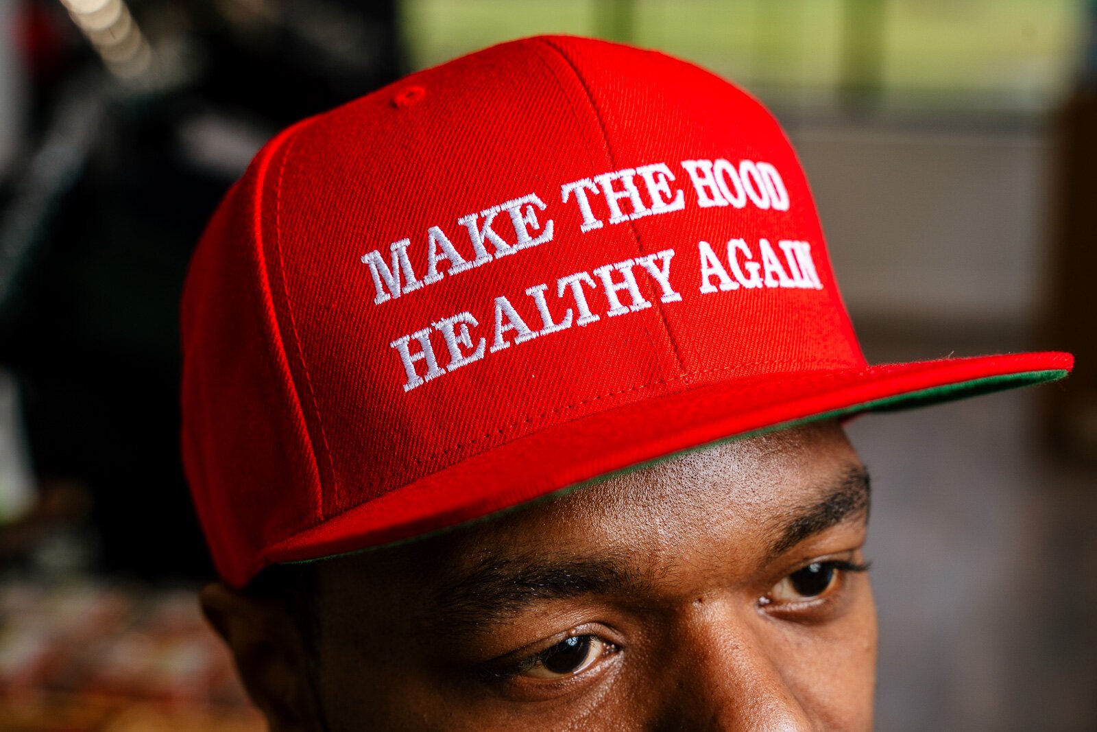 Grimes wears a "Make the Hood Healthy Again" hat, sold at Neighborhood Grocery.