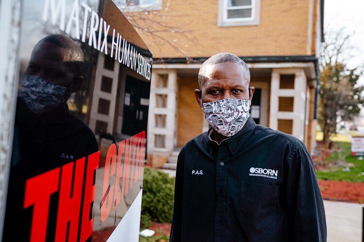 Osborn Business Association Business Manager Paul Garrison dons a mask in front of his group's offices.