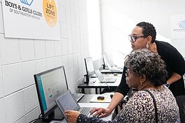 Comcast Director of Community Impact for Michigan, Indiana and Kentucky Shannon Dulin shows Detroit resident Gwendolyn Jones how to access some programs she's looking forward to using at the Certified Tech Hub.
