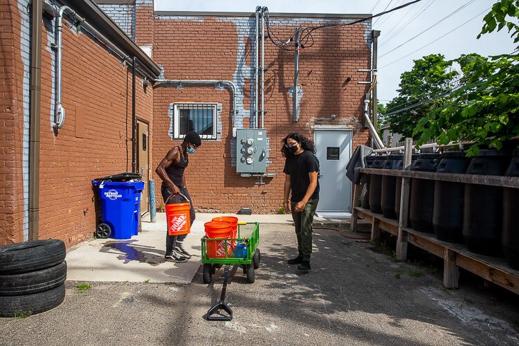 Members of SFC fill up water barrels for their garden.