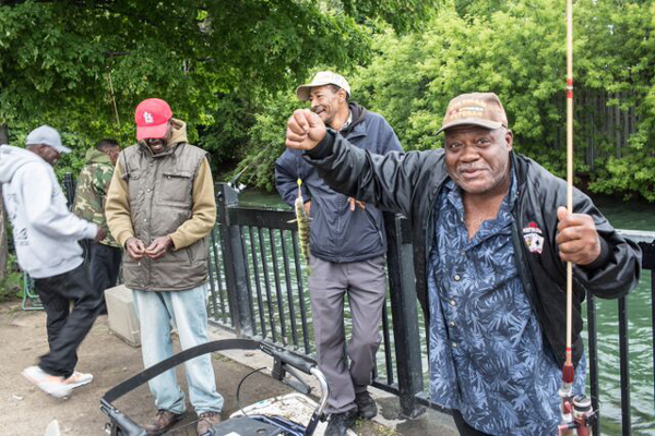 Using perch for bait along Fox Creek at Mariner's Park, this group of fishermen meet every Saturday in summer. Across the creek and behind the fence is Grosse Pointe Park.