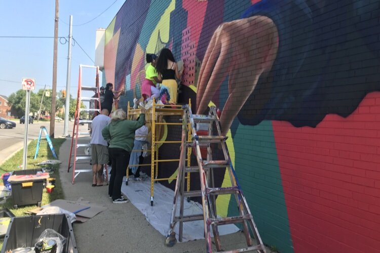 A collaborative spirit was on full display at the mural worksite, where professional artists and POP Design Team alumni were on hand to guide the high school students through the process.