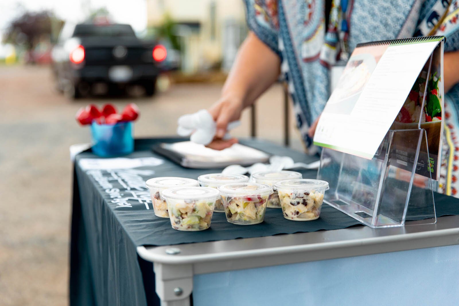 MARESA Nutrition Educator Michelle Granger sets up a food taste test at the CSA pickup.