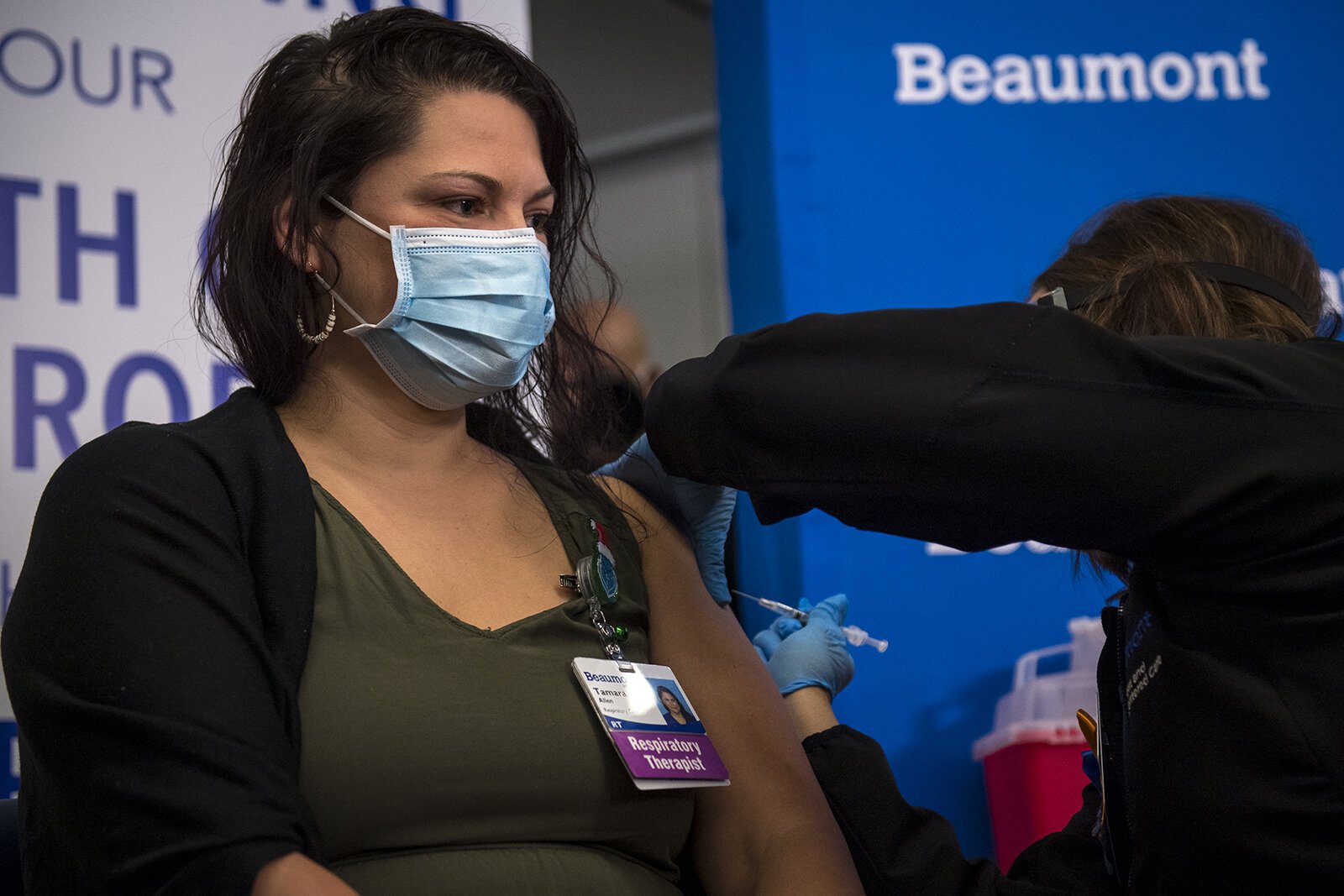 Susan Grant administers the first dose of the COVID-19 vaccine to Respiratory Therapist Tamara Allen at Beaumont Service Center in Southfield on Dec. 15, 2020.