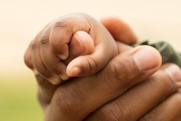 Parent holding infant's hand