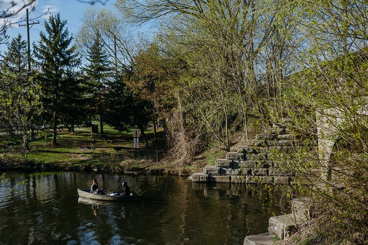 Canoers float down the Huron River next to River's Edge Brewing Company in Milford.