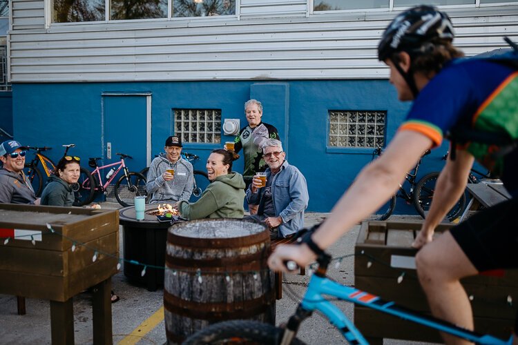 Members of the cycling group Spoke Junkies gather outside River's Edge Brewing Company in Milford after their bi-weekly ride.